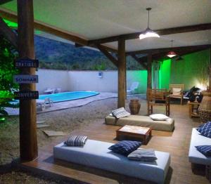 a living room with a couch and a swimming pool at Itamambuca Casa de Praia in Ubatuba