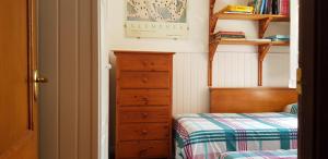 une petite chambre avec un lit et une commode dans l'établissement Casa Magda, à Vigo