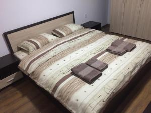 1 cama grande con 2 toallas encima en Dunav Apart en Ruse