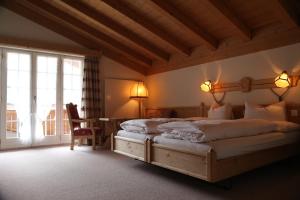 a bedroom with two beds and a table and a window at Hotel Alte Post in Grindelwald