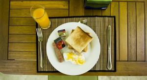 un piatto di prodotti per la colazione e un bicchiere di succo d'arancia di Off Day Inn a Città di Malé