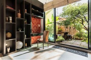 a living room with a large window and a chair at Nappark Hostel @Khao San in Bangkok