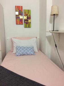 Cette petite chambre comprend un lit rose avec un oreiller. dans l'établissement Suria Kipark Single Bedroom Apartment, à Kuala Lumpur