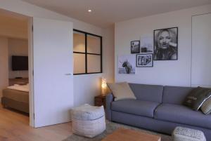 a living room with a couch and a bed at Appartement met Zeezicht in Ostend
