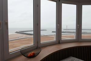 a room with windows with a view of the ocean at Appartement met Zeezicht in Ostend