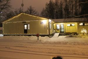 a house covered in christmas lights in the snow at Guesthouse - Kuin Kotonaan in Kotka +14 photos