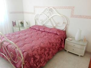 Schlafzimmer mit einem Bett mit einer roten Bettdecke in der Unterkunft By the sea in Scario in Scario