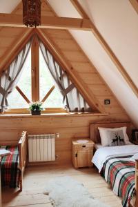 a attic bedroom with two beds and a window at BIAŁY PUCH in Zakopane