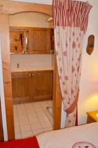 a kitchen with wooden cabinets and a curtain at ECRINS ETOILE C9 in Samoëns