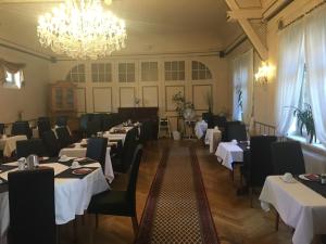 a dining room with tables and chairs and a chandelier at Hotel Mainzer Hof in Dieburg