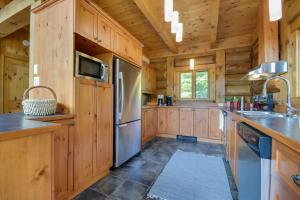 a kitchen with wooden cabinets and a refrigerator at Log Cabin Home with Lake and Mountain view by Reserver.ca in Sainte-Adèle