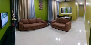 a living room with two chairs and a flat screen tv at Mintsuite homestay in Putrajaya