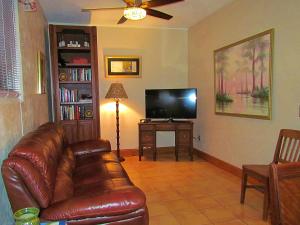 a living room with a leather couch and a flat screen tv at The Yearling Cabins in Cross Creek