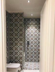a bathroom with a toilet and a tiled wall at Camere Delle Rose in Milan