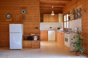 eine Küche mit einem weißen Kühlschrank und Holzwänden in der Unterkunft Ferienhaus Wagner in Bad Ischl