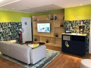 a living room with a couch and a flat screen tv at ibis Paris Montmartre Sacré-Coeur in Paris