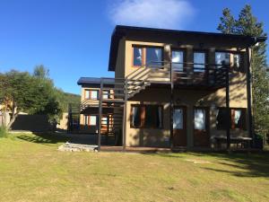 una casa grande con un gran patio delante en Deptos Punta Nevada en San Carlos de Bariloche
