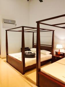 Livinya Holiday Resort في كاتاراغاما: غرفة نوم بسريرين بطابقين مع مصباح