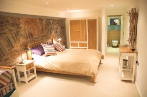 a bedroom with a large bed with a painting on the wall at No1 The Pottery, Dartmouth in Dartmouth