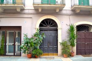 een gebouw met een zwarte deur en enkele planten bij Angiulli 50 in Bari