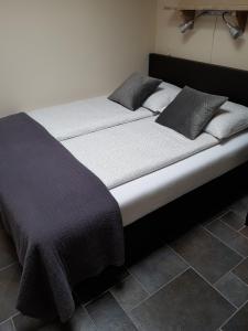 a bed in a room with two pillows on it at Mooi zo 2 in De Koog