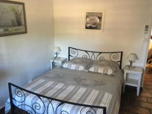 ein Schlafzimmer mit einem Bett mit zwei Nachttischen und zwei Lampen in der Unterkunft Mas de charme Les Pellegrins in Saintes-Maries-de-la-Mer