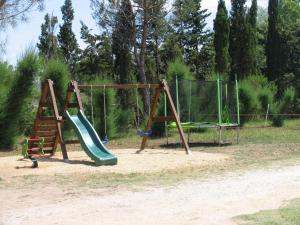 einen Spielplatz mit zwei Schaukeln und einer Rutsche in der Unterkunft Mas de charme Les Pellegrins in Saintes-Maries-de-la-Mer