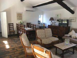 a living room with a couch and a table and chairs at Mas de charme Les Pellegrins in Saintes-Maries-de-la-Mer