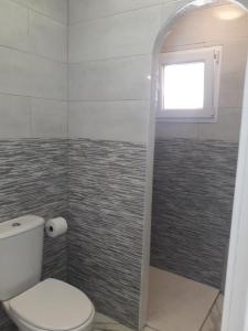 a bathroom with a toilet and a window at BEAUTIFUL SMALL APARTAMENT in Costa Calma