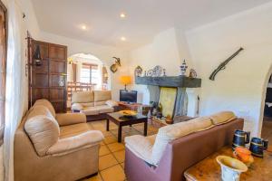 a living room with two couches and a fireplace at Holiday Home El Alcázar in Alcaucín