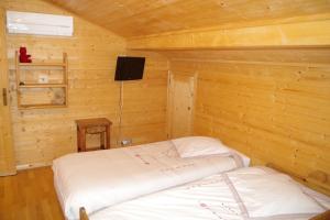 - une chambre avec un lit dans une cabane en bois dans l'établissement Chalet Le Sabot De Venus, à Combloux