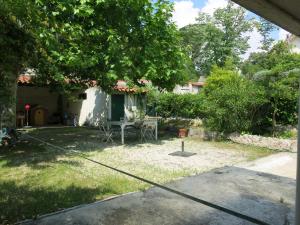 a yard with a table and chairs under a tree at Maison avec jardin sur une colline in Marseille