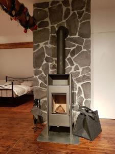 a stone fireplace with a stove in a room at Klementina in Vrbovsko
