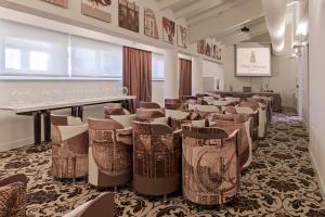 a room with a bunch of chairs and tables at Hotel Armonia in Pontedera