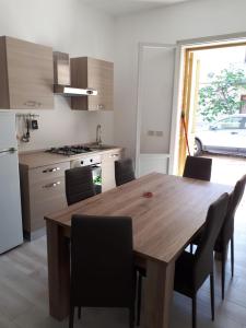 a kitchen with a wooden dining table and chairs at Villa Donati in Cesenatico