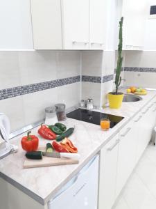 eine Küchentheke mit Gemüse auf einem Schneidebrett in der Unterkunft Apartmani Abbazia in Banja Luka + 11 Fotos