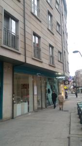 a building on a city street with people walking past it at Apartamento Centro Porriño in Porriño