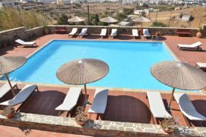 a swimming pool with chairs and umbrellas at Paradisia Villas in Naxos Chora
