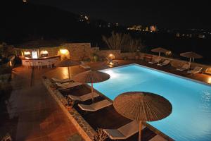 a swimming pool with umbrellas and lounge chairs at Paradisia Villas in Naxos Chora
