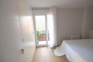 biała sypialnia z łóżkiem i oknem w obiekcie Tocando la Catedral by Exclusive Burgos Apartments w mieście Burgos