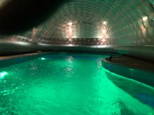 a swimming pool with green water in a tunnel at Apartments Villa Stella Maris in Rogoznica