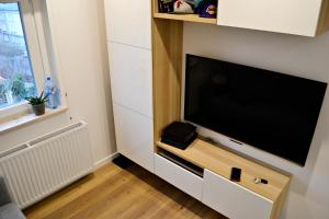 a living room with a large flat screen tv at Studio 4 Piętro in Sopot