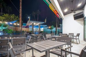 a restaurant with wooden tables and chairs at night at CCBC Resort Hotel - A Gay Men's Resort in Cathedral City