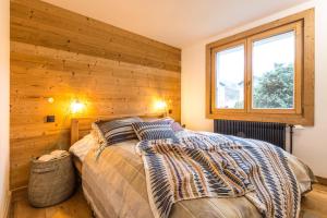 1 dormitorio con 1 cama con pared de madera en Appartement Native en Chamonix-Mont-Blanc