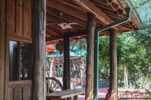 a wooden pavilion with a table and a bench at Palo Rosa Lodge in Puerto Iguazú