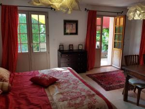 a bedroom with a bed and a desk and windows at LES PALMIERS TOULON in Toulon