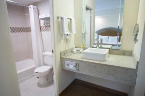 a bathroom with a sink and a toilet and a mirror at Best Western PLUS Monterrey Colón in Monterrey