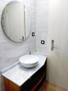 ein Badezimmer mit einem weißen Waschbecken und einem Spiegel in der Unterkunft Apartamento MARIA in Usana