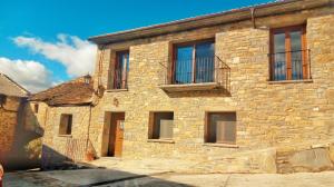 ein altes Steingebäude mit Fenstern und Balkon in der Unterkunft Apartamento MARIA in Usana