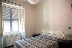 a white bedroom with a bed and a window at Casa della Posta in Borzonasca
